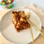 Házi marharagus lasagne olvadt mozzarellával rétegezve, szeletelve, paradicsomos szósszal és zöldséges raguval készítve.