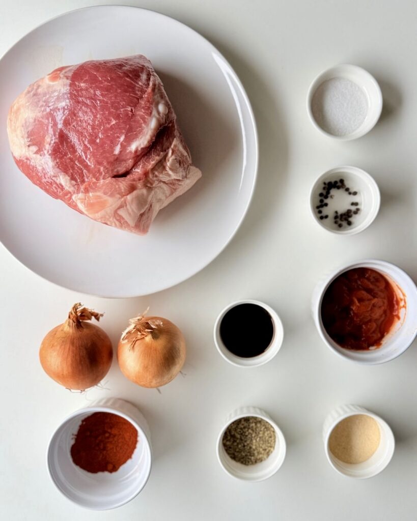 Sütőben sült, szaftos tépett tarja vöröshagymával, szójaszósszal és fűszerekkel, fehér tányéron tálalva