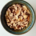 Sütőben sült, szaftos tépett tarja vöröshagymával, szójaszósszal és fűszerekkel, fehér tányéron tálalva