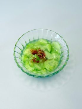 Hagyományos ecetes uborkasaláta vékonyra szeletelt kígyóuborkából, pirospaprikával megszórva.