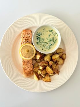 Sütőben sült lazac krémes spenótos-parmezános tejszínes mártással tálalva.