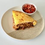 Rétegezett chilis bab torta teljes kiőrlésű tortilla lapokkal, darált marhahússal, vörösbabbal, tejföllel és olvadt sajttal sütve.