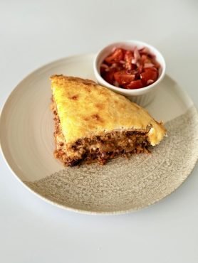 Rétegezett chilis bab torta teljes kiőrlésű tortilla lapokkal, darált marhahússal, vörösbabbal, tejföllel és olvadt sajttal sütve.