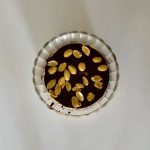 Rétegezett Snickers pohárdesszert görög joghurttal, mogyoróvajjal, étcsokoládéval és mogyoródarabokkal a tetején.