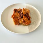 Sajtos-paradicsomos rakott cukkini darált marharaguval, bazsalikomos ricottával és olvadt mozzarellával.