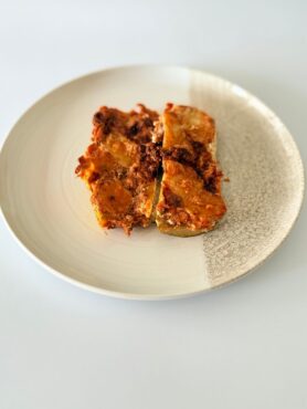 Sajtos-paradicsomos rakott cukkini darált marharaguval, bazsalikomos ricottával és olvadt mozzarellával.
