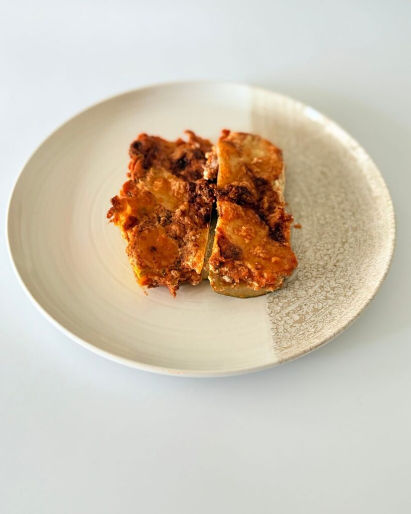 Sajtos-paradicsomos rakott cukkini darált marharaguval, bazsalikomos ricottával és olvadt mozzarellával.